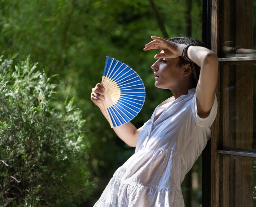 Young,Woman,Suffering,Heatstroke,Outdoors,Using,Fan,To,Get,Fresh