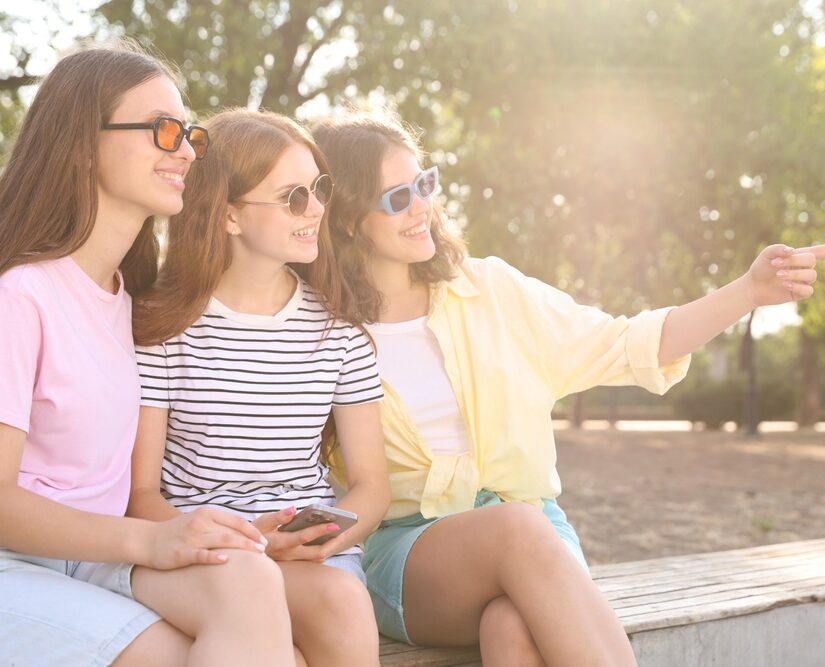 Happy,Friends,In,Sunglasses,On,Bench,Outdoors
